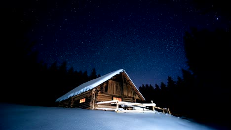 time-lapse. hermosa casa de madera en el bosque de invierno bajo las estrellas