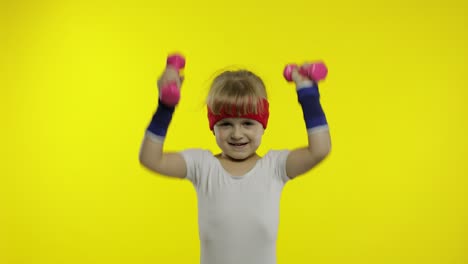 Caucasian-girl-in-sportswear-making-exercises-with-dumbbells.-Workout-for-kids.-Athletic-child