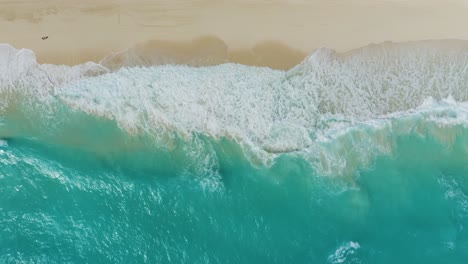 Vista-De-Pájaro-De-Arriba-Hacia-Abajo-De-Las-Olas-Rompiendo-En-La-Playa-Tropical-De-Arena-Blanca