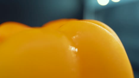 a macro close up detailed shot of a wet sweet yellow pepper on a 360 rotating stand, shiny sweaty water drops, cinematic studio lighting, super slow motion, 120 fps, smooth movement, full hd video