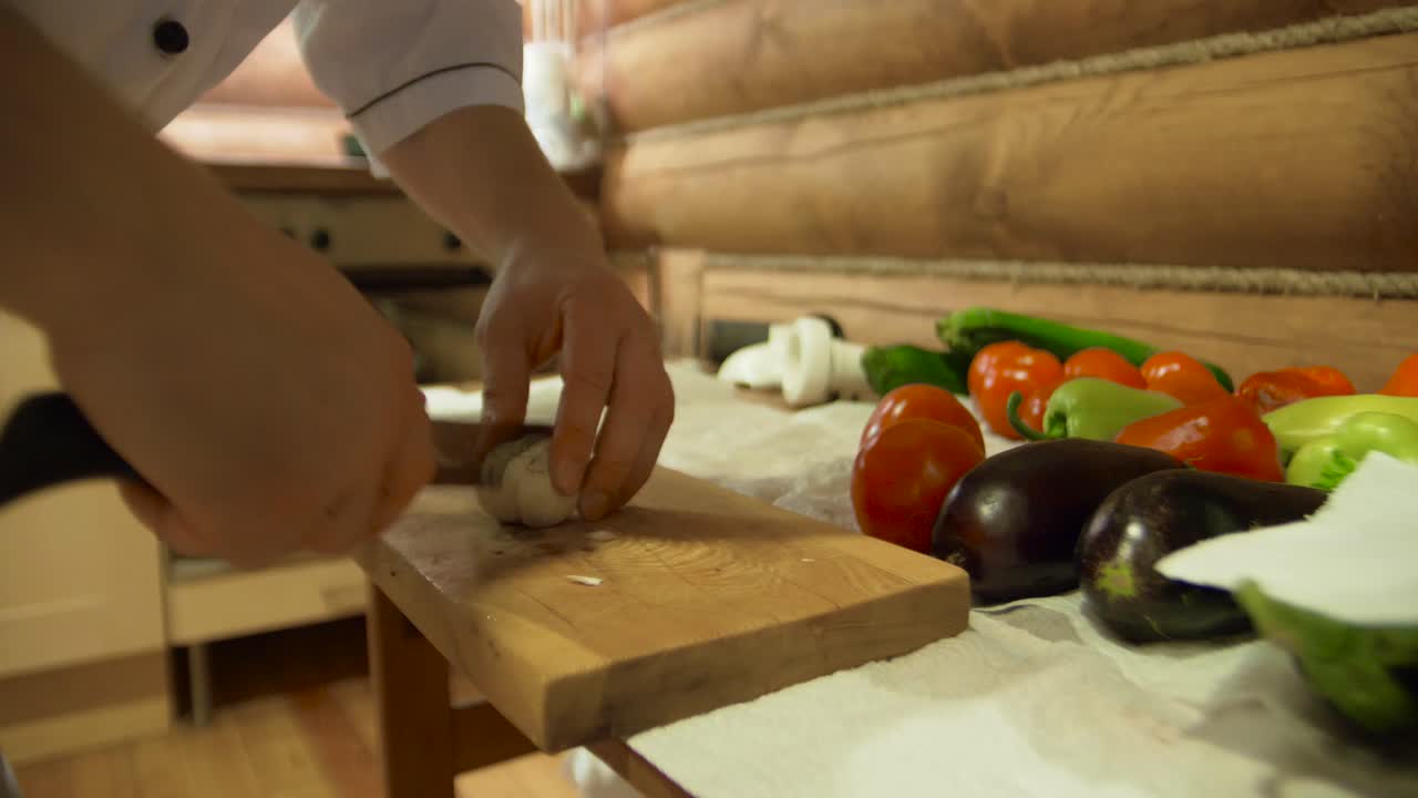 요리사 가 로그 오두막 주방 에서 채소 를 준비 하고 있다