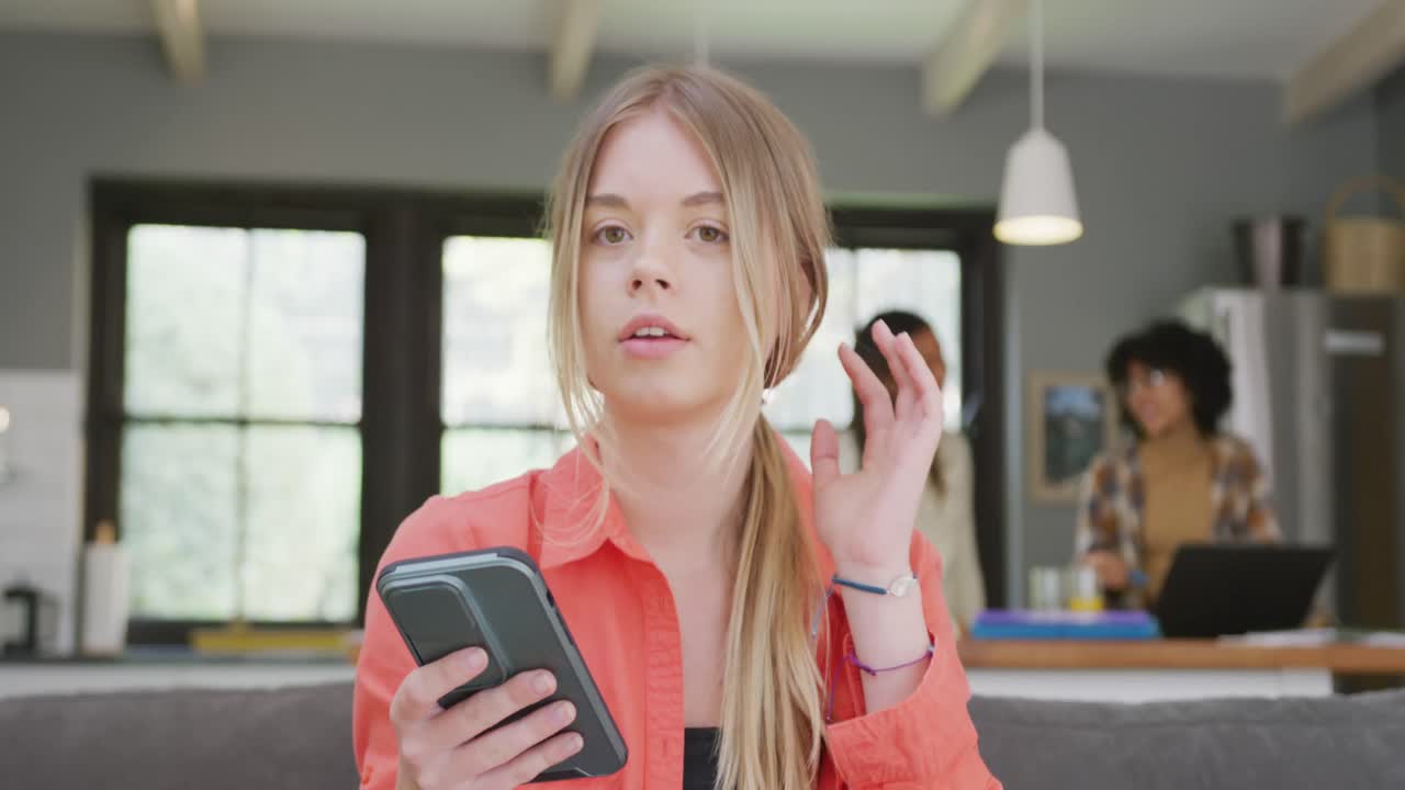 amigas adolescentes diversas haciendo una videollamada en el teléfono inteligente en casa, cámara lenta