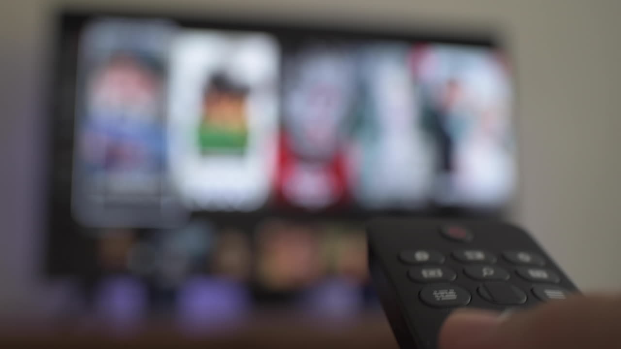 primer plano de una persona que usa el control remoto de tv para seleccionar qué ver en la televisión