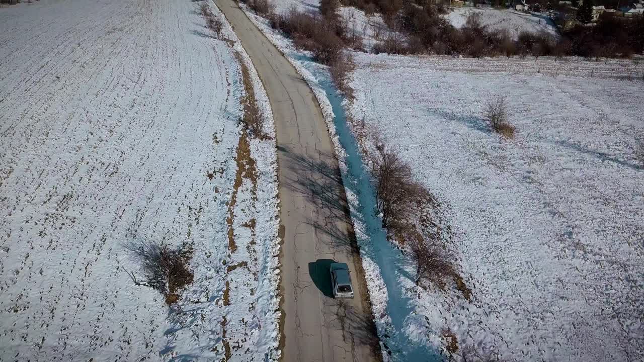 conducir un automóvil en un día soleado de nieve en una carretera despejada