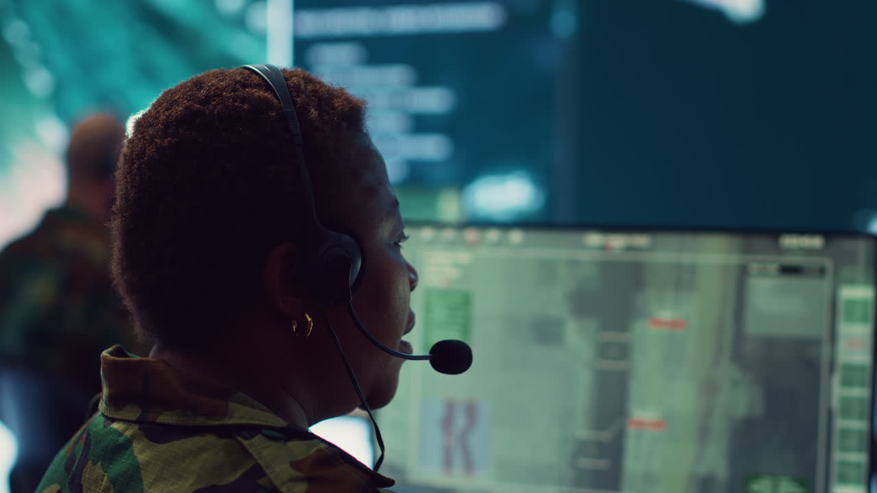 una mujer oficial del ejército opera con imágenes de vigilancia gps para recopilar información.