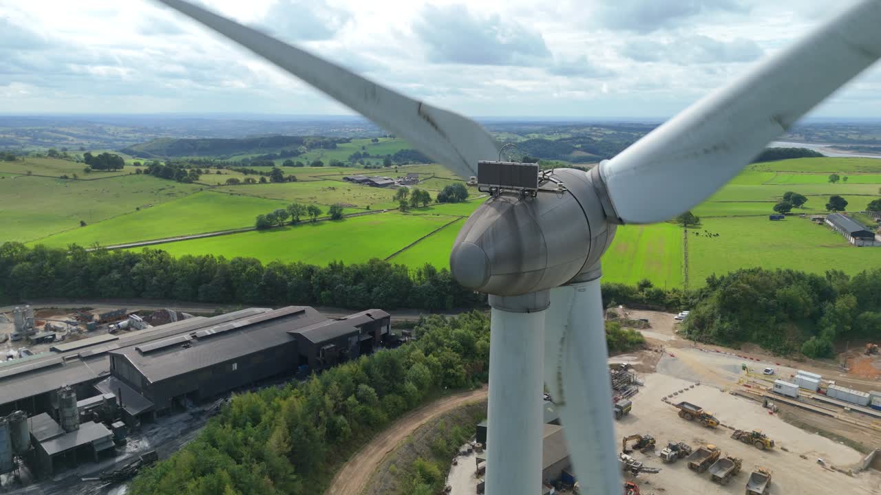 Drone overflight of Carsington quarry, wind turbines, and lake surrounded by rolling green landscape in the Derbyshire countryside