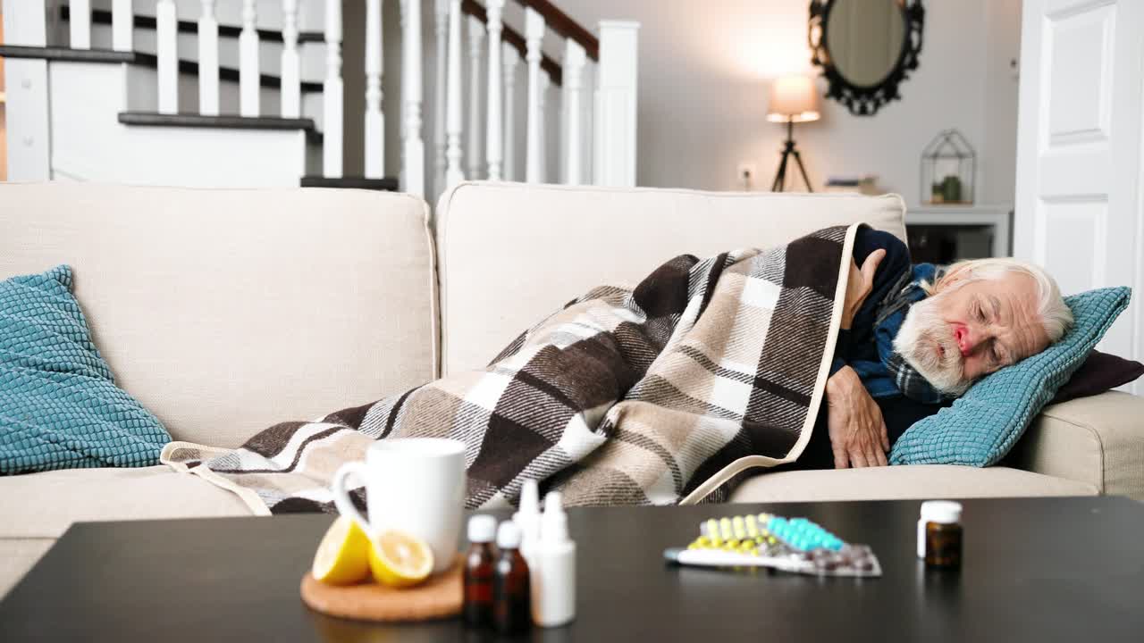 Very sick senior man lying on sofa in living room