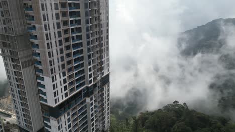 drone flies in the vicinity of skyscrapers under construction in the genting highlands in malaysia - background nature and many mountains