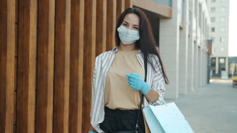 woman shopping in city wearing a mask and gloves