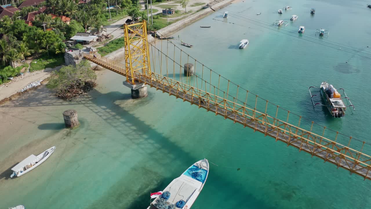 A bright, high-angle aerial drone shot capturing the famous Yellow Bridge (Jembatan Kuning) which connects the islands of Nusa Lembongan and Nusa Ceningan