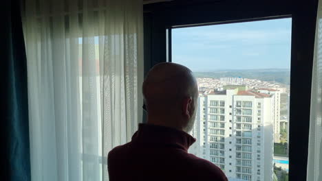 man with recent hair transplant speaks on the phone from a hotel room in istanbul, turkey