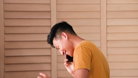smiling man at home talking on smartphone, enjoying casual conversation, copy space