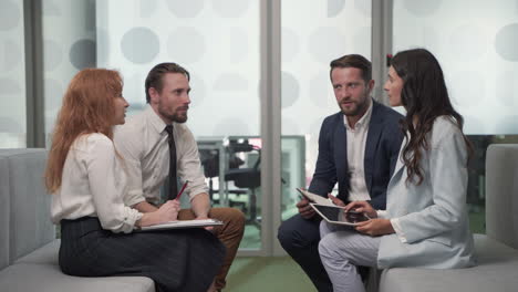 a working group of two businesswomen and two businessmen in the middle of a brainstorming session