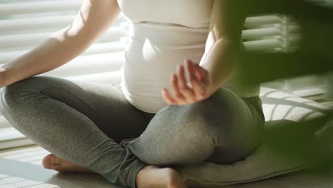 Pregnant-woman-meditating-in-the-sunbeams-on-floor.