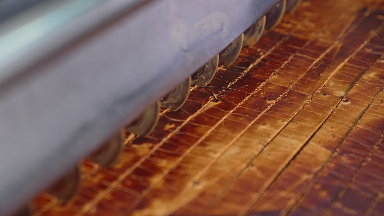 Production of candies at the factory. Automated process of cutting the sweet layer of desserts. Close up.