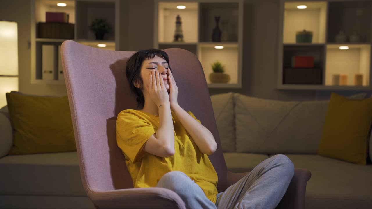 Giovane donna depressa che si copre il viso con la mano.