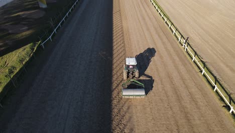 seguimiento aéreo de un rodillo atado con un tractor utilizado para la compactación del suelo en la pista del hipódromo