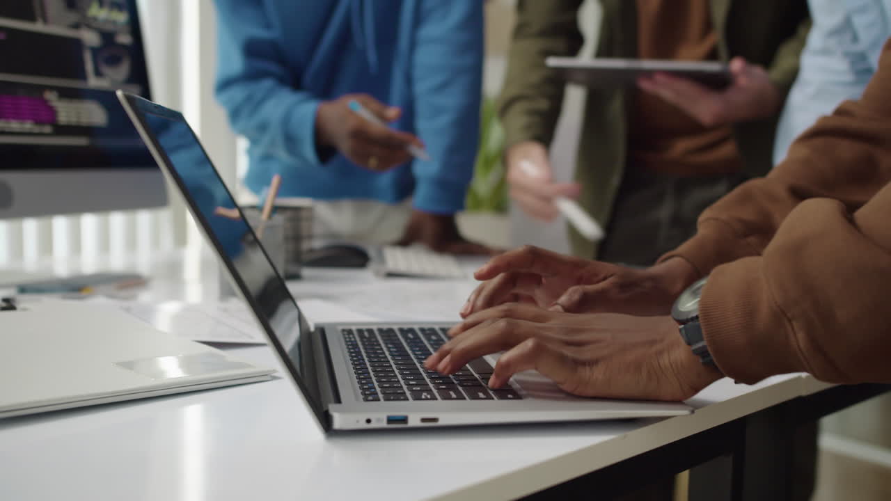Unrecognizable Developer Coding on Laptop when Meeting with Team at Office