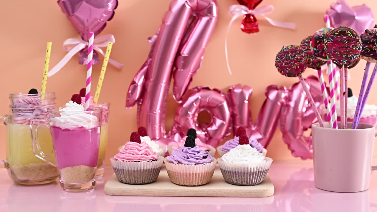 mesa dulce con postres para fiestas y celebraciones. pasteles de taza, pasteles y pudines con globos