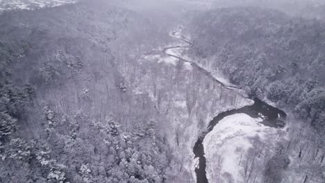 Winding-River-cuts-Through-a-Winter-Landscape-in-Northern-Canada-Alpine-Forest-Valley,-tracking-Aerial-Drone-Toronto-Canada