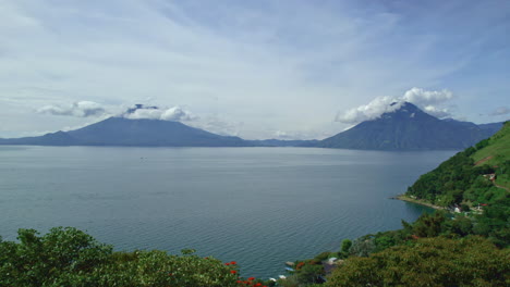 drone aerial footage of guatemalan volcanos volcan de atitlan and volcan san pedro in central american highlands lake atitlan, guatemala