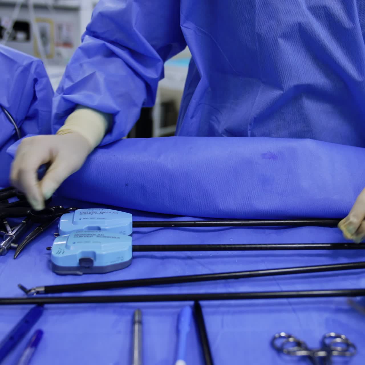 Hands in gloves put the endowrist instruments on the table. Robotic equipment is prepared for the operation