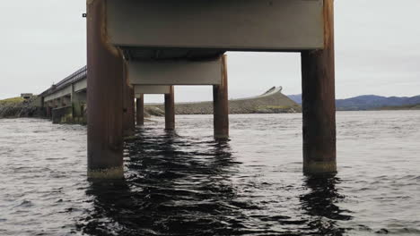 wavy wave underneath bridge carrying atlantic ocean road in norway