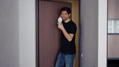 Smiling-man-takes-off-his-medical-mask-of-coronavirus-protection-at-home