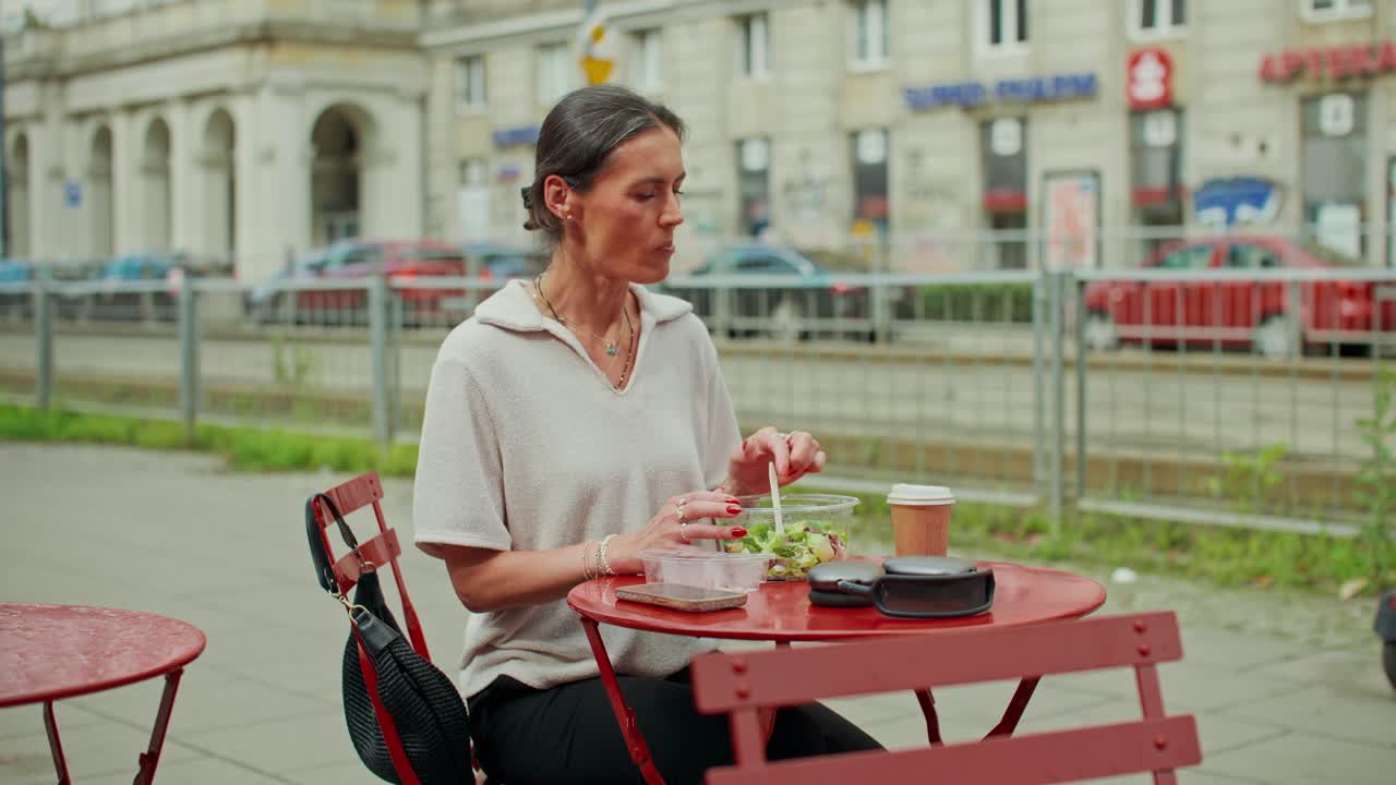 Donna che mangia un'insalata in un bar all'aperto