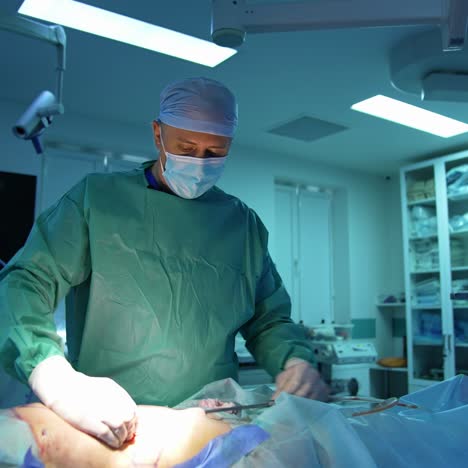 surgeon operating patient in operation room. doctor working during surgery in operating room