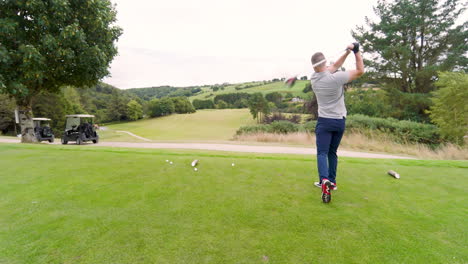 male golf player playing golf, hitting the ball with club on a golf course