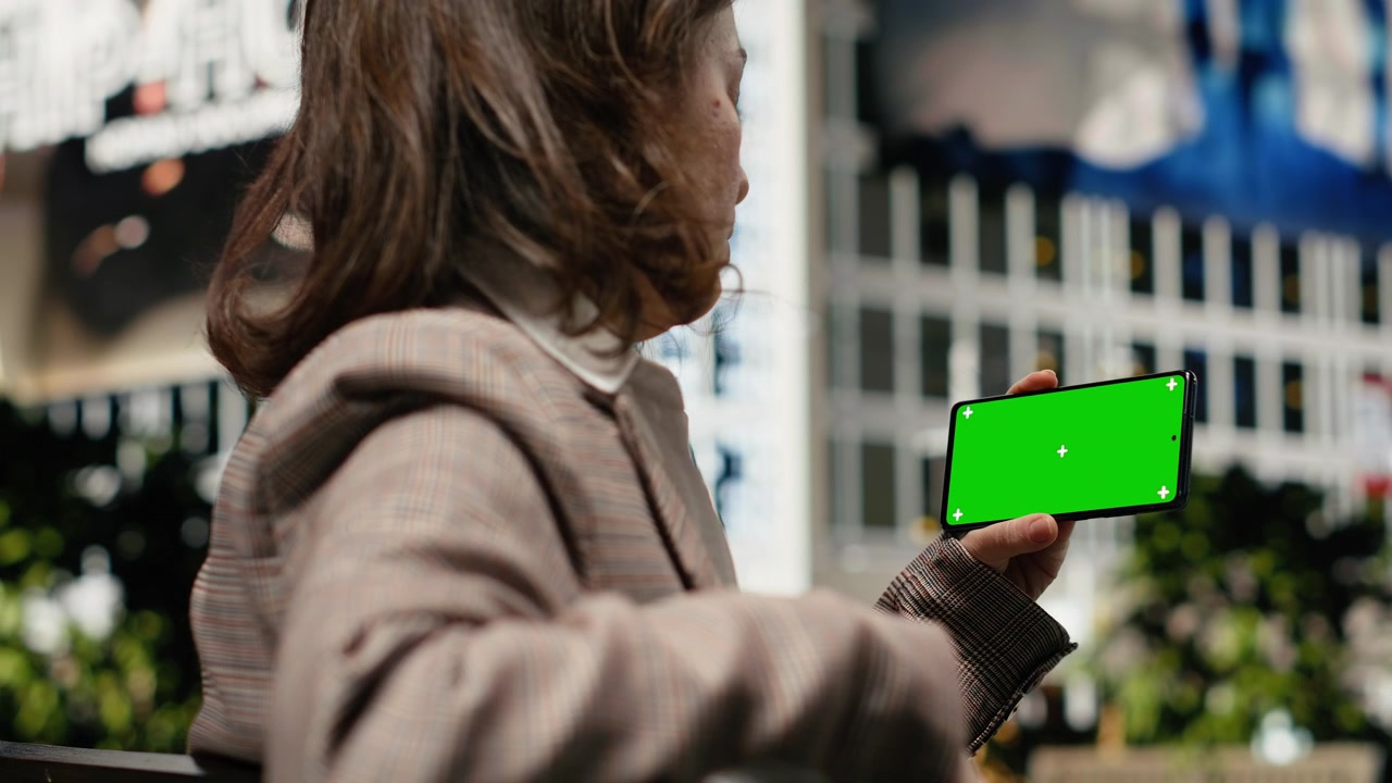 Smartphone mockup usato da una donna d'affari che si rilassa su una panchina di legno.