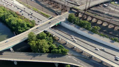 aerial drone top down shot of traffic flowing smoothly on a bright summer day, train tracks, transportation concept