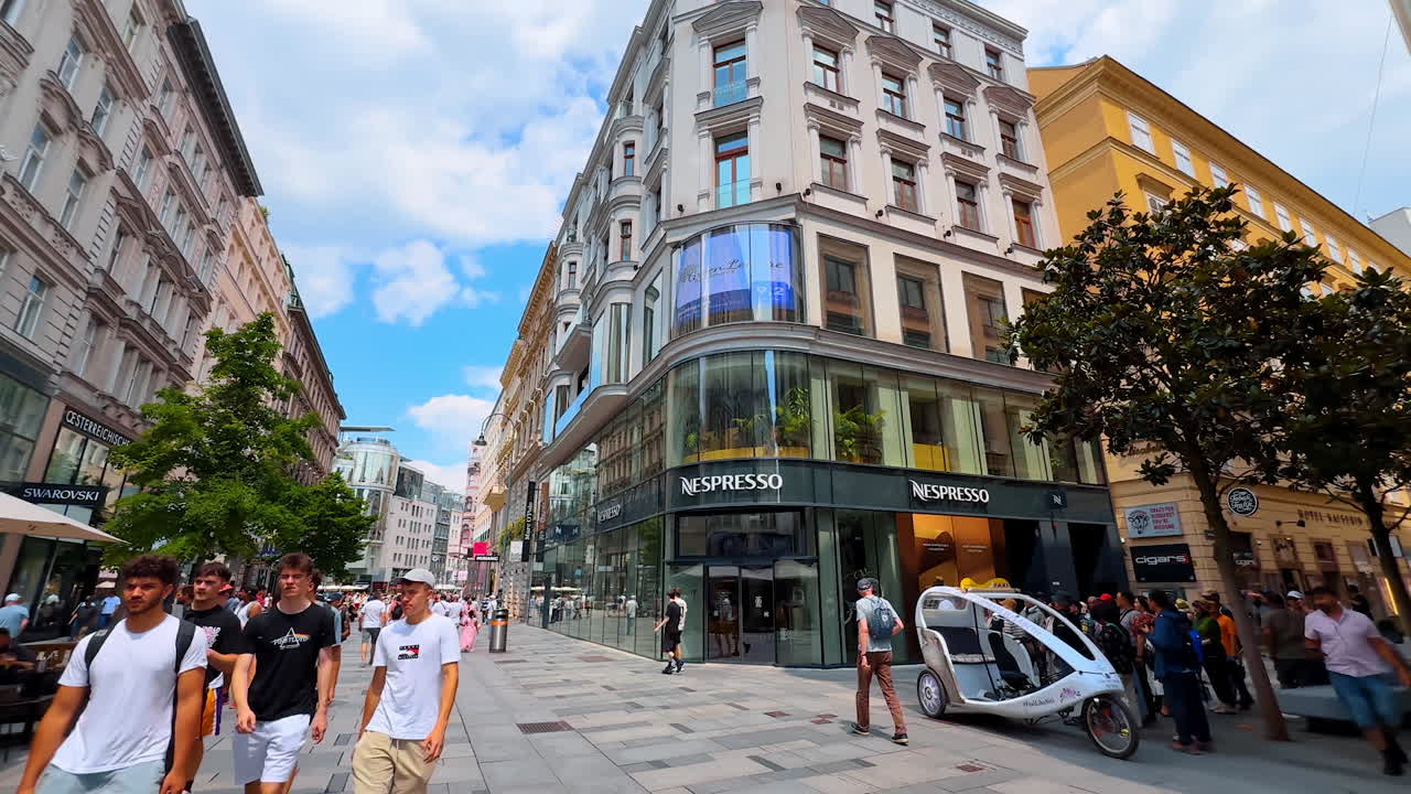Vienna, Austria - June 9, 2025: Tourists in sunny Wien. Tourists explore vibrant streets of Wien, Austria, engaging in shopping and dining under a clear sky