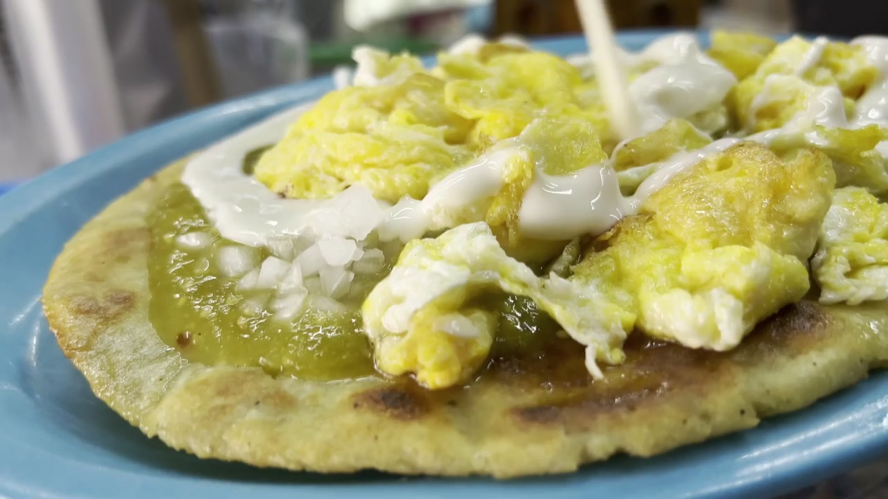 Vendedor local sirviendo huarache, una torta de maíz mexicana con salsa
