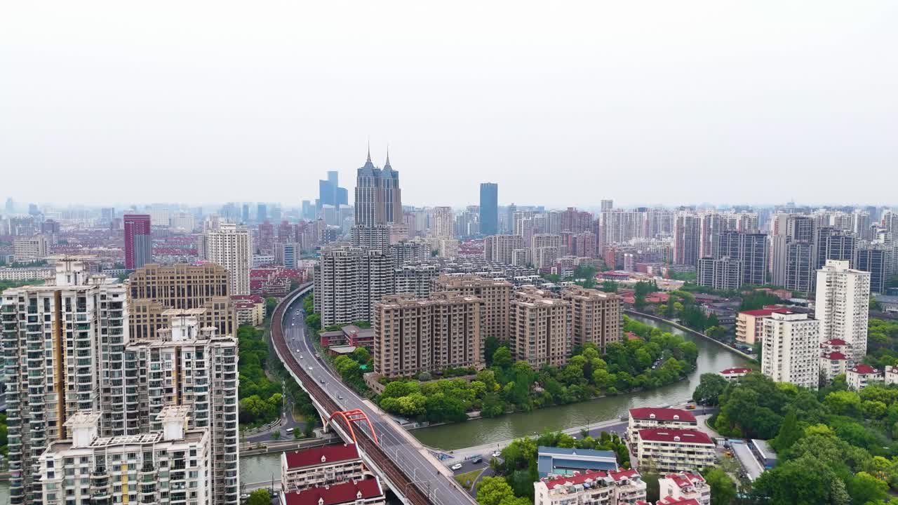 Aerial view of Shanghai cityscape on a hazy day. Features buildings along Suzhou Creek, showcasing urban density and river view. China