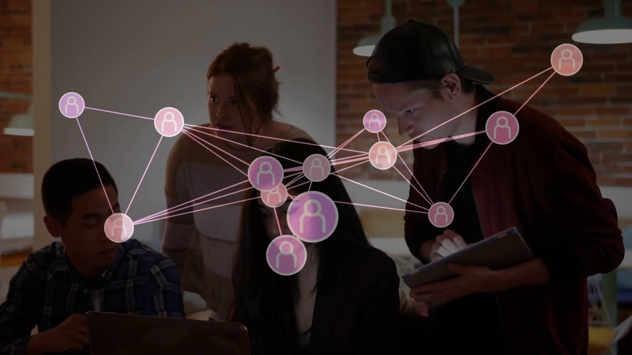 Team working around laptop, network overlay emerging over center, analyzing business data