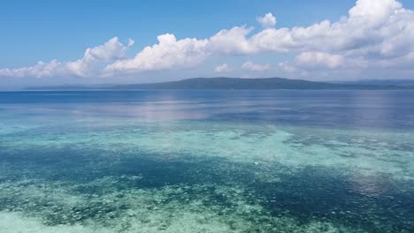 aerial drone rising over coral reef ecosystem in crystal clear ocean water of raja ampat, west papua, indonesia