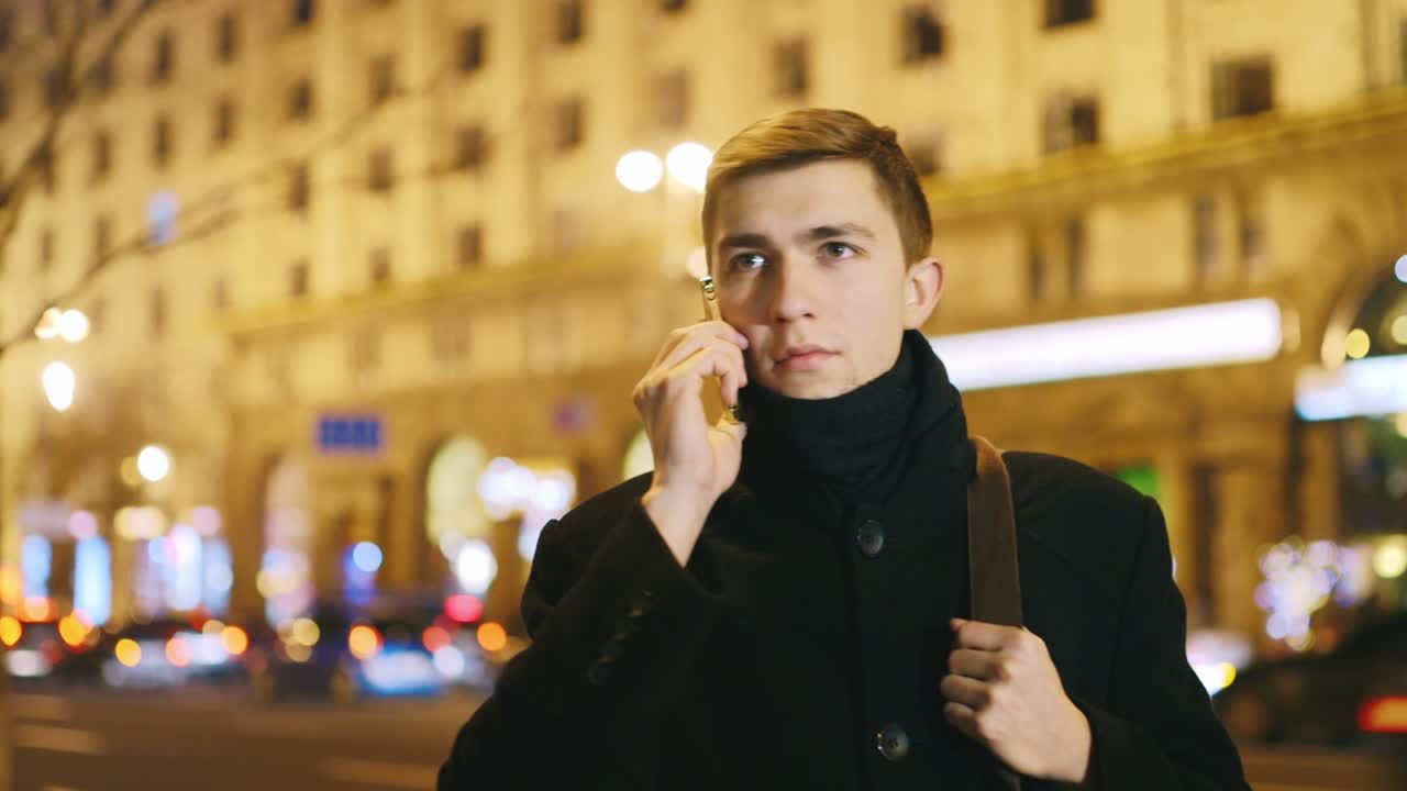 молодой человек разговаривает по телефону на фоне ночного города 1