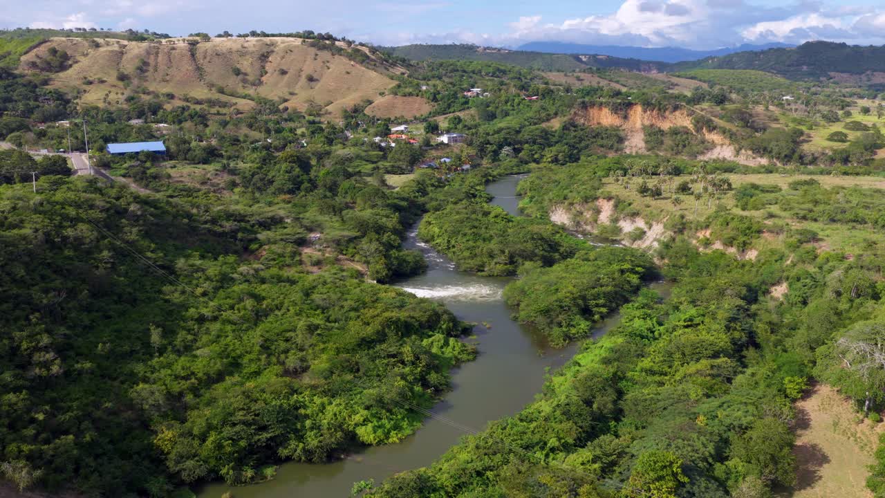 Vista drone in volo sul bellissimo fiume Yaque del Norte, circondato da lussureggianti colline verdi e foresta tropicale, nella provincia di Santiago, Repubblica Dominicana. Ripresa aerea in avanti