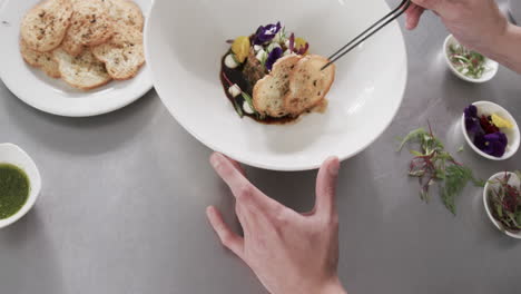 caucasian male chef decorating meal in kitchen, slow motion