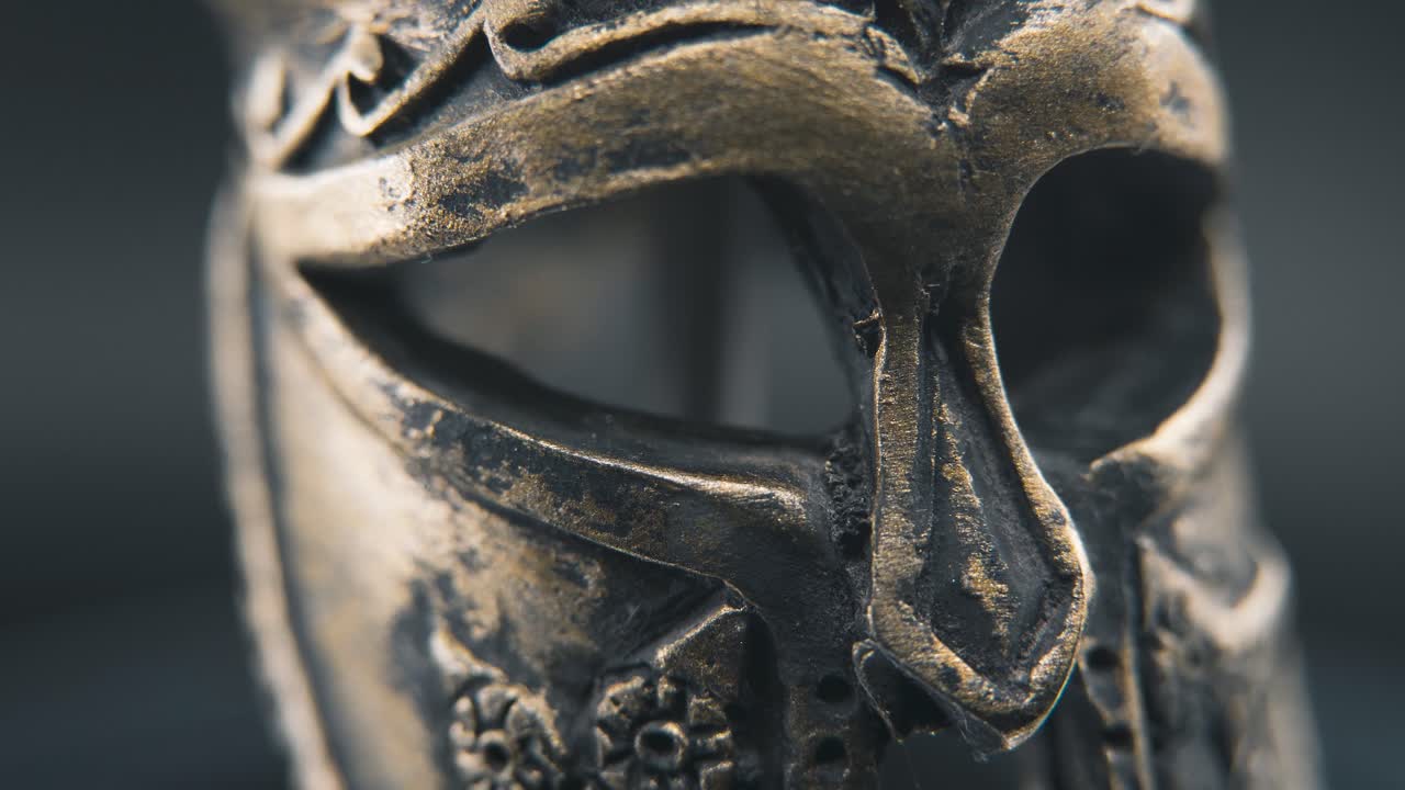 un macro profesional de primer plano, una toma lenta a la derecha de un diseño de rostro espartano, un casco de bronce griego antiguo, en un soporte giratorio de 360, iluminación de estudio, movimiento suave de 4k