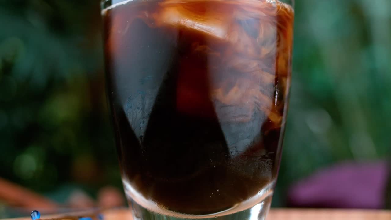 Primer plano de un vaso con café oscuro o té.