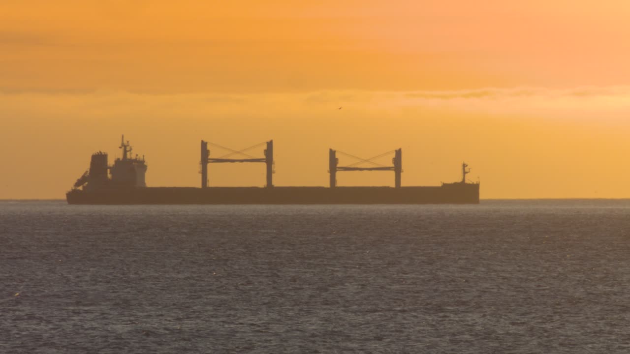 새 무리와 큰 보트가 있는 대서양 일몰