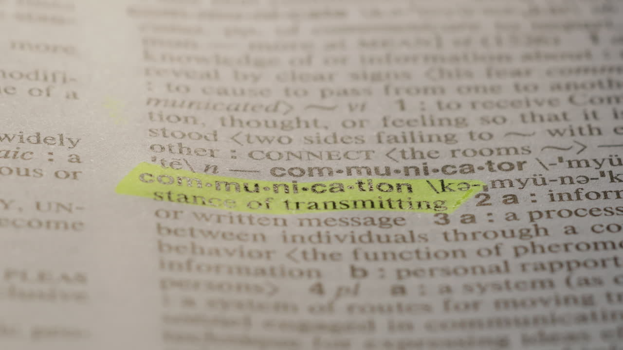 Communication Business Dictionary Highlighter Concept, highlighting a word in a dictionary to show it's definition