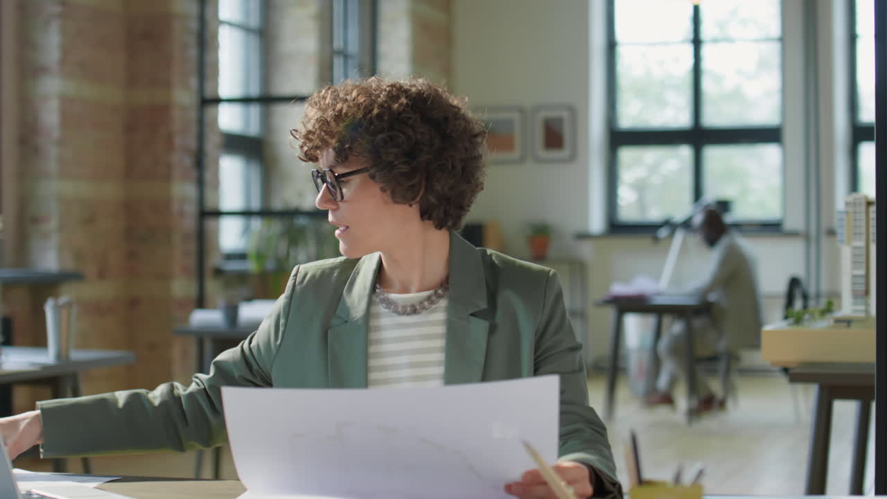 Professional Woman Architect Working on Blueprints in a Modern Office