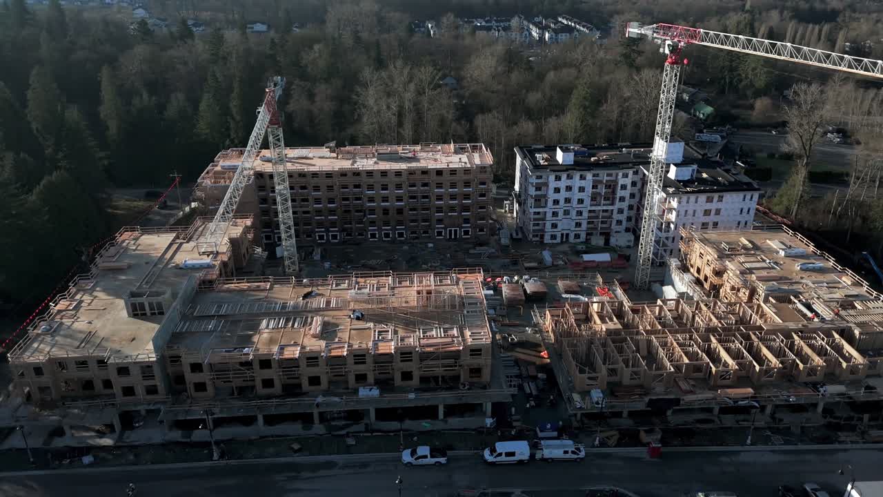 Langley, British Columbia, Canada - A Residential Complex Under Construction With Cranes and Wooden Framing - Orbit Drone Shot