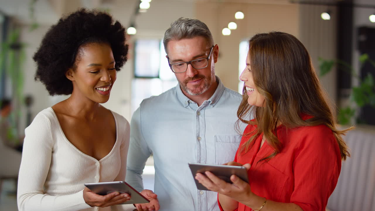 equipo de negocios multicultural con tabletas digitales que se reúnen en una oficina moderna de diseño abierto