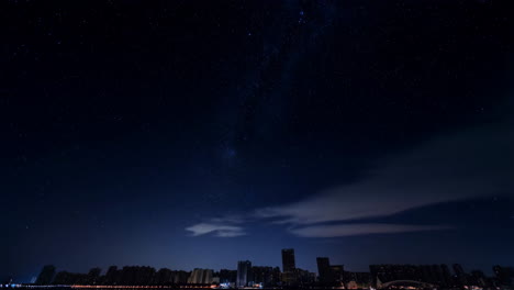 city skyline at night with clouds and stars