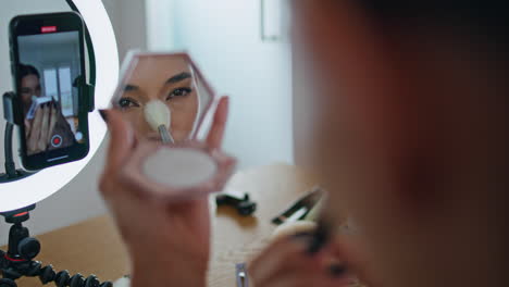 influencer woman applying makeup looking mirror at house closeup. blogger visage